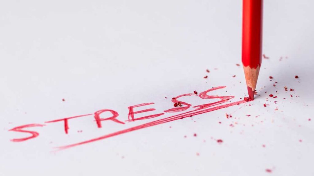 Le mot stress écrit en rouge avec un crayon de couleur dont la mine se casse.